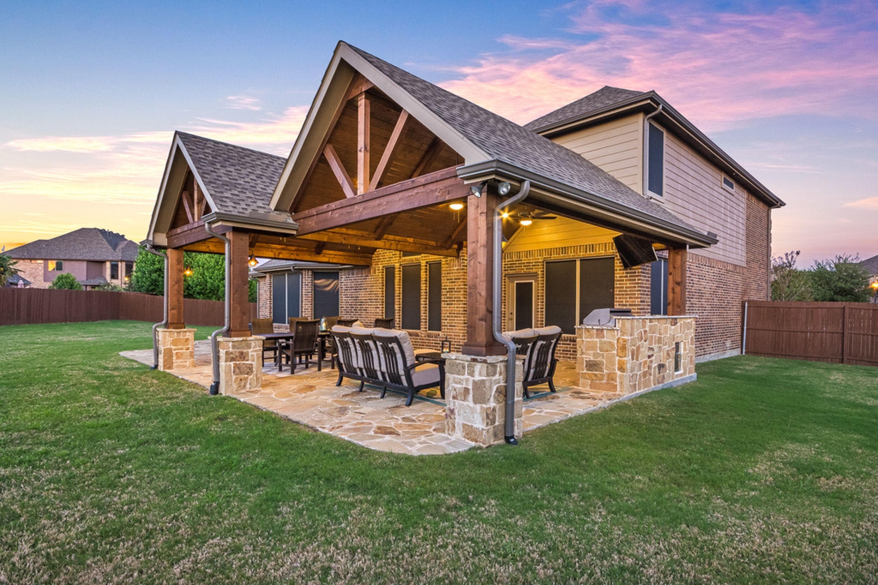 Cedar wood patio cover with shingle roof on a limestone home near Old Town Round Rock