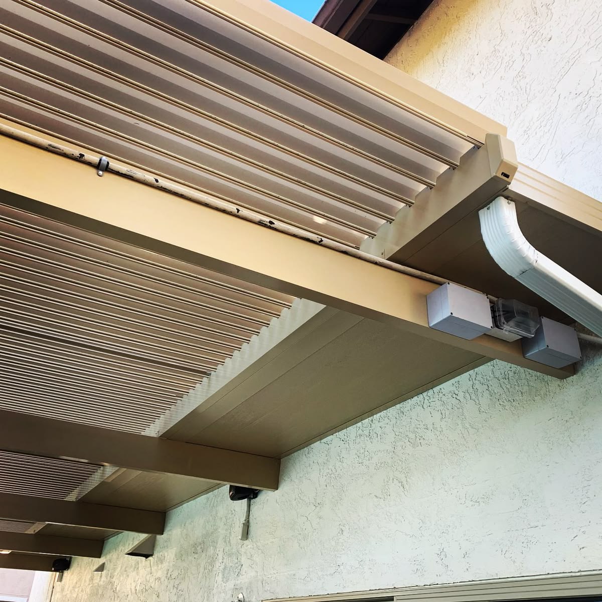Close-up of interlocking aluminum louvers and the integrated gutter on a louvered pergola