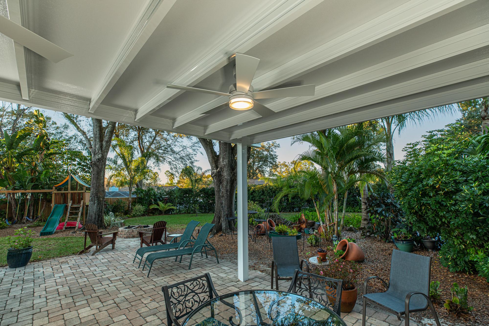 Electrician mounting a wet-rated ceiling fan to an insulated aluminum patio cover