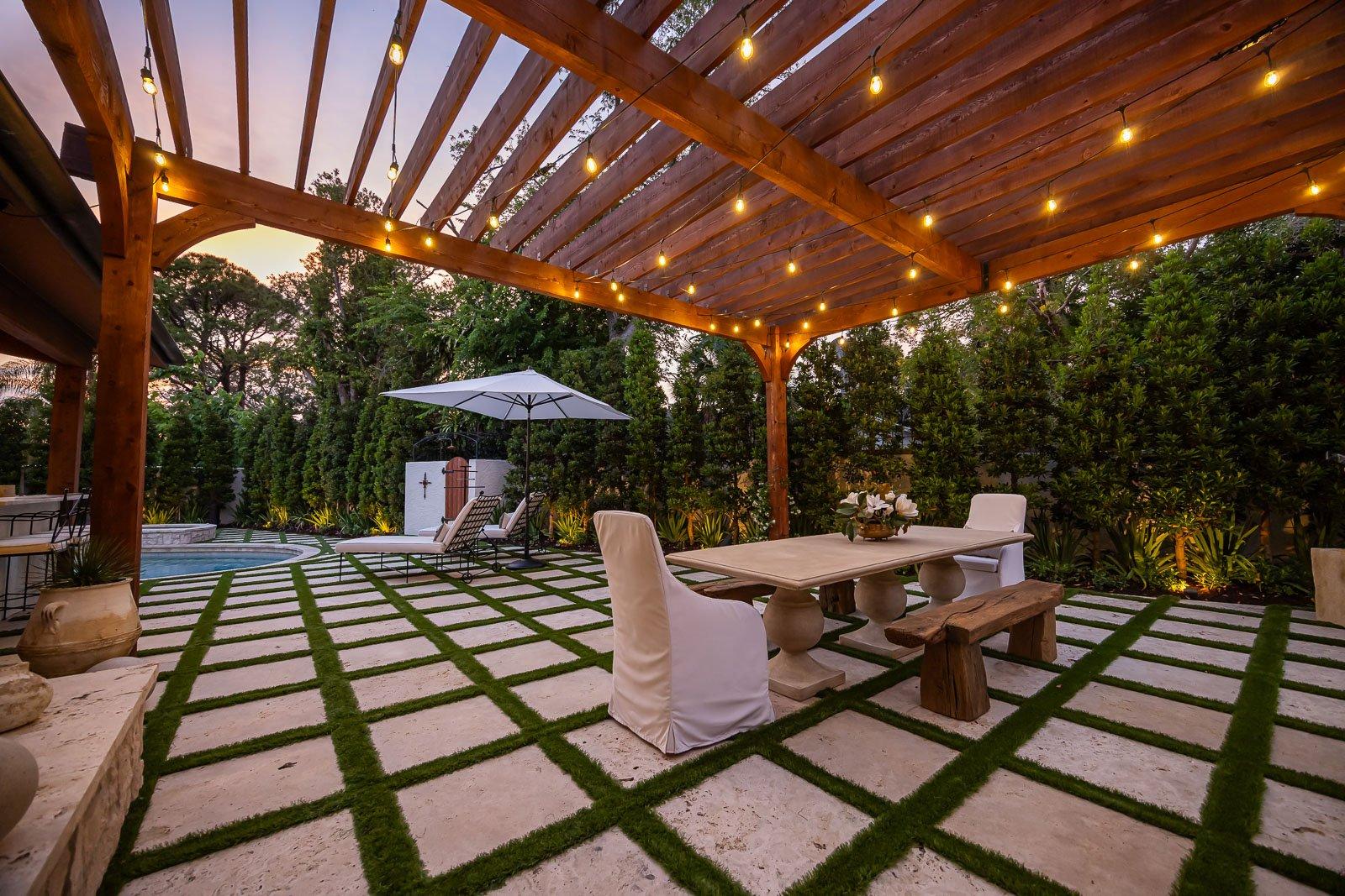 Cedar pergola with string lights over a dining table on a Round Rock patio at dusk