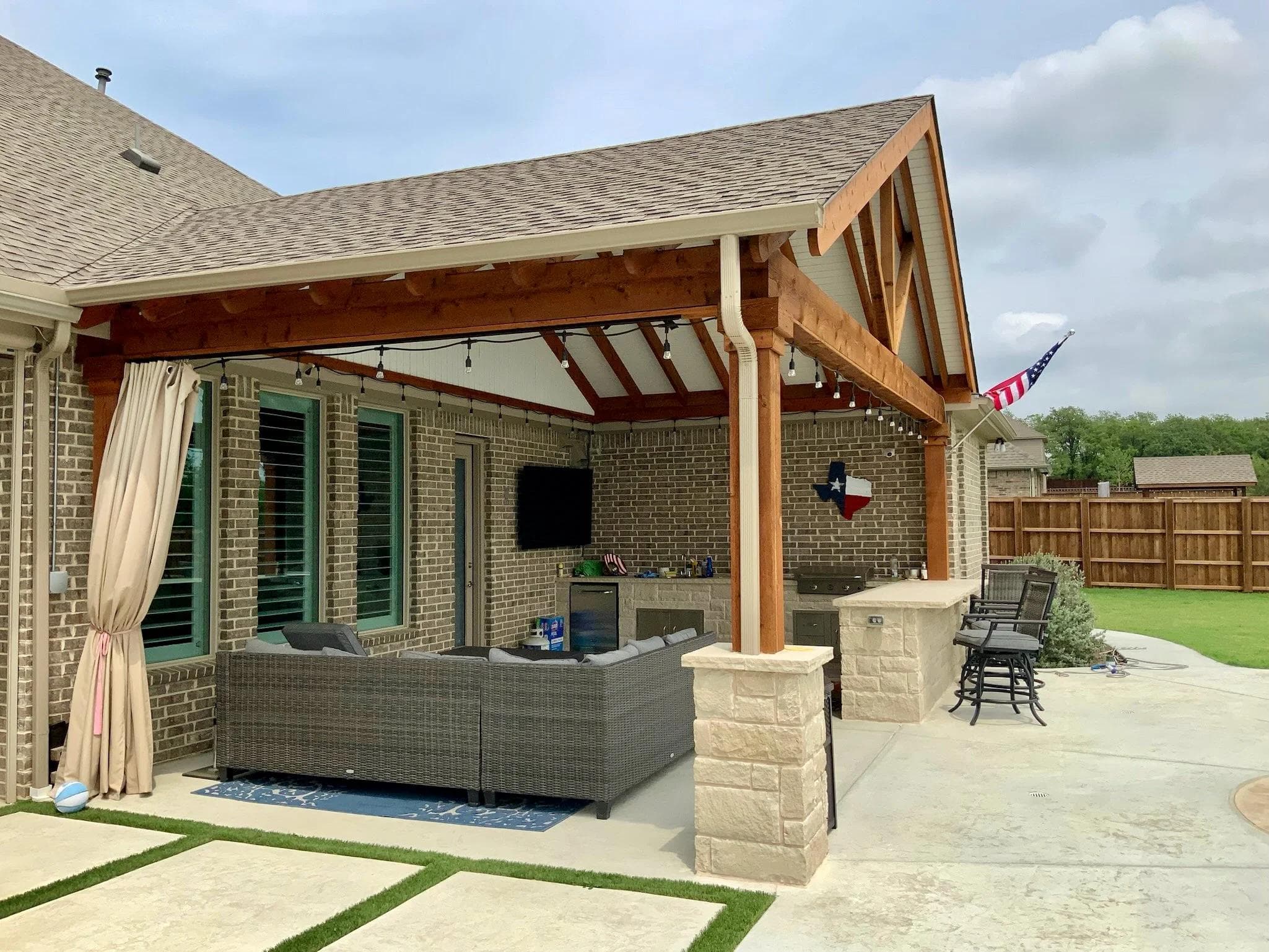 Cedar wood patio cover with shingle roof on a historic home in Taylor, Texas