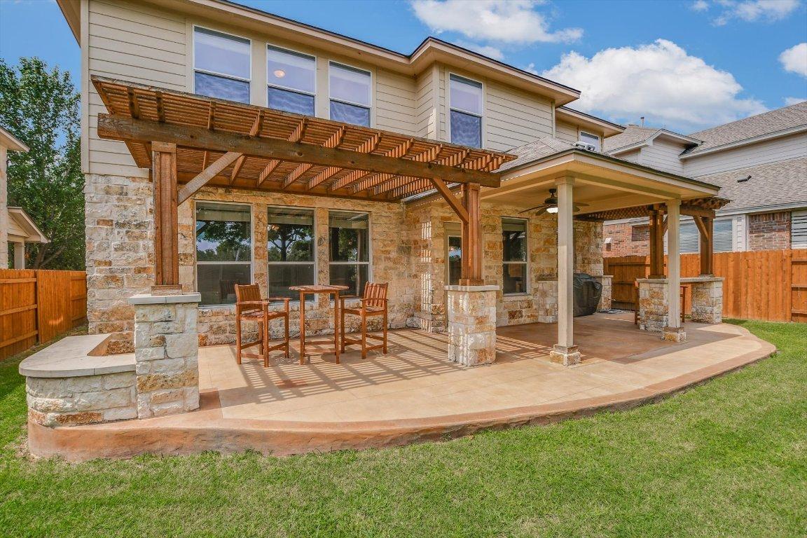 Cedar wood patio cover with stone columns on a Cedar Park home backing to a greenbelt