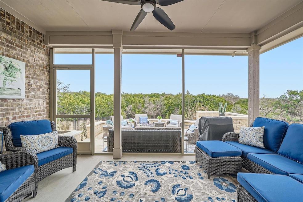 Screened patio enclosure with seating and a ceiling fan on a Round Rock home near a greenbelt