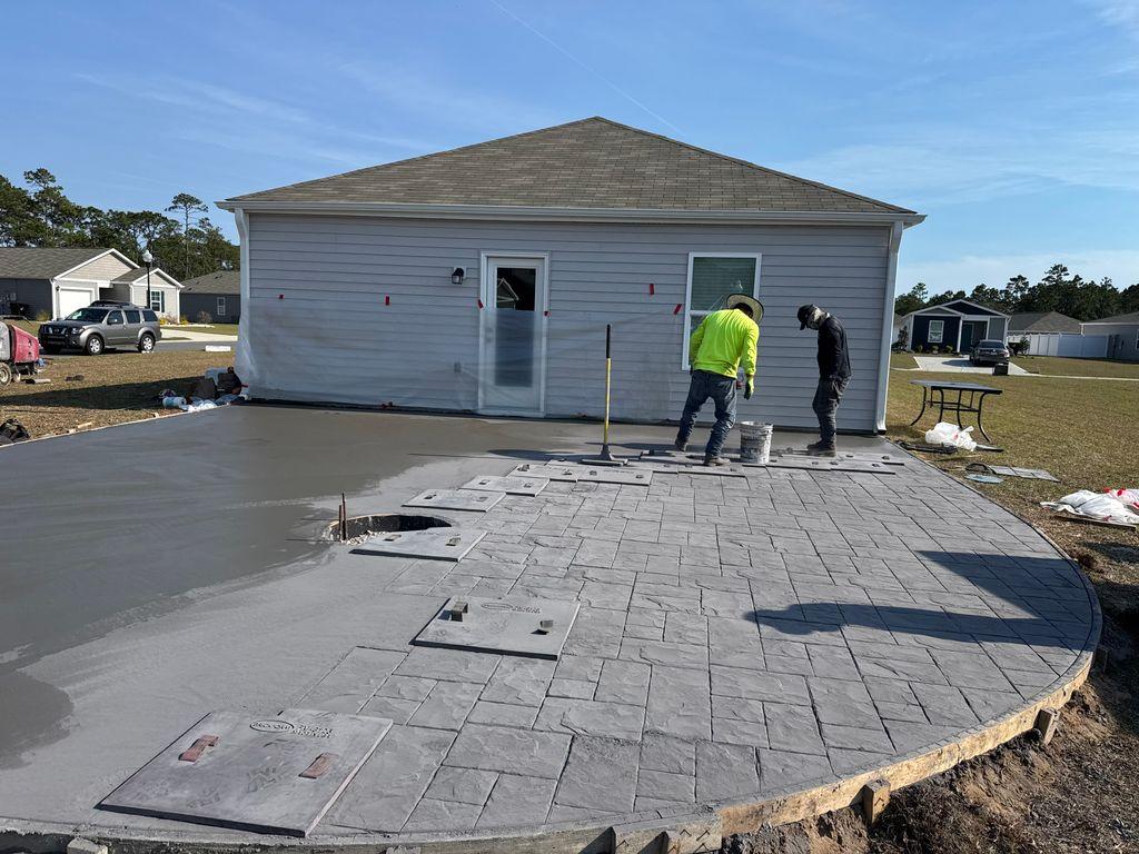 Stamped concrete patio extension being poured behind a Round Rock home before a patio cover install