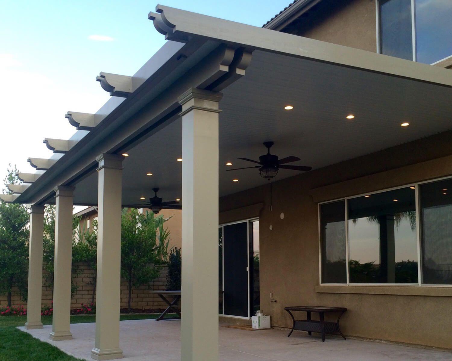 Insulated aluminum patio cover in wood-grain finish with recessed lights on a Round Rock two-story home