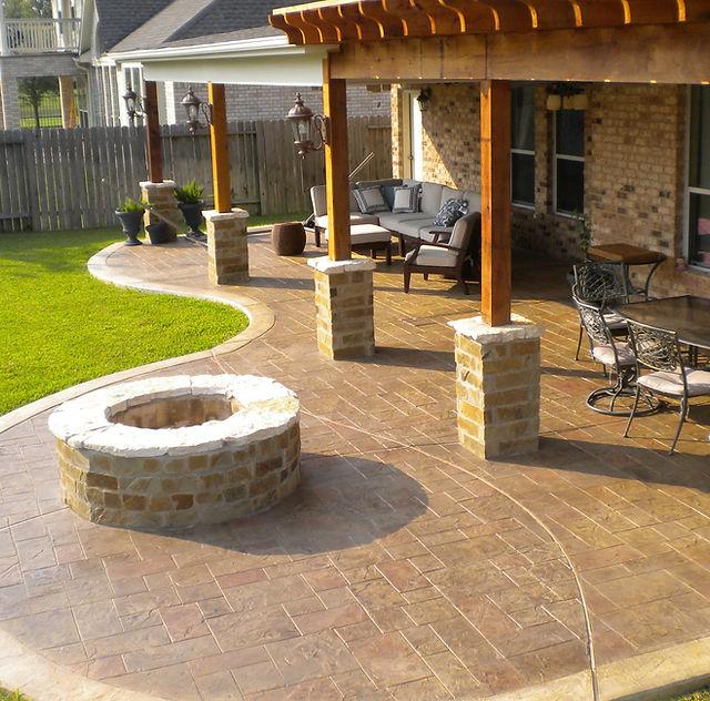 Stamped concrete patio with a stone border and post footings for a patio cover in Round Rock